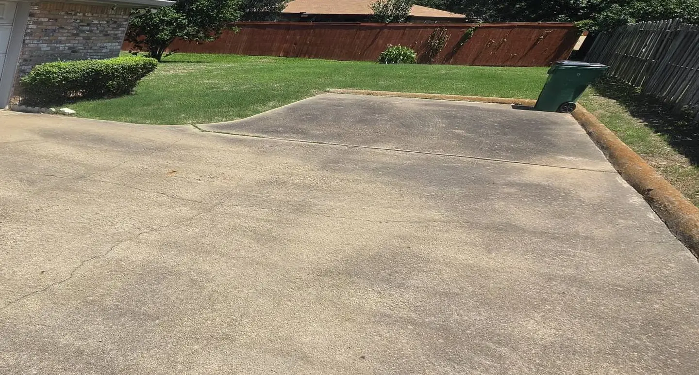 Before: concrete driveway with dark, blotchy stains