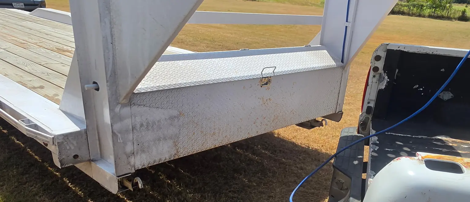 Before: white gooseneck trailer front with rust-colored stains and grime