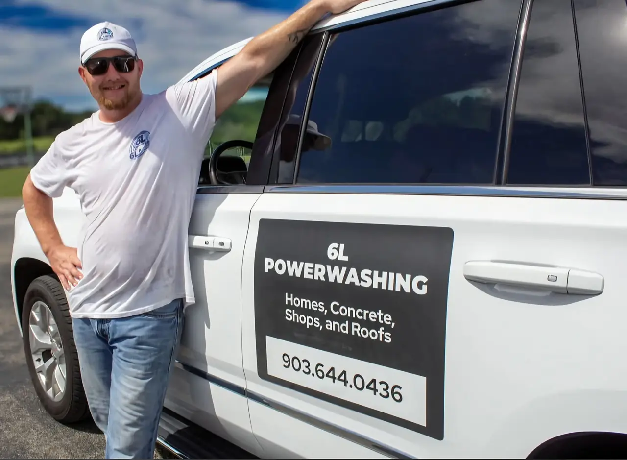Man in a 6L Power Washing T-shirt leaning on a white SUV with a 6L Powerwashing door sign